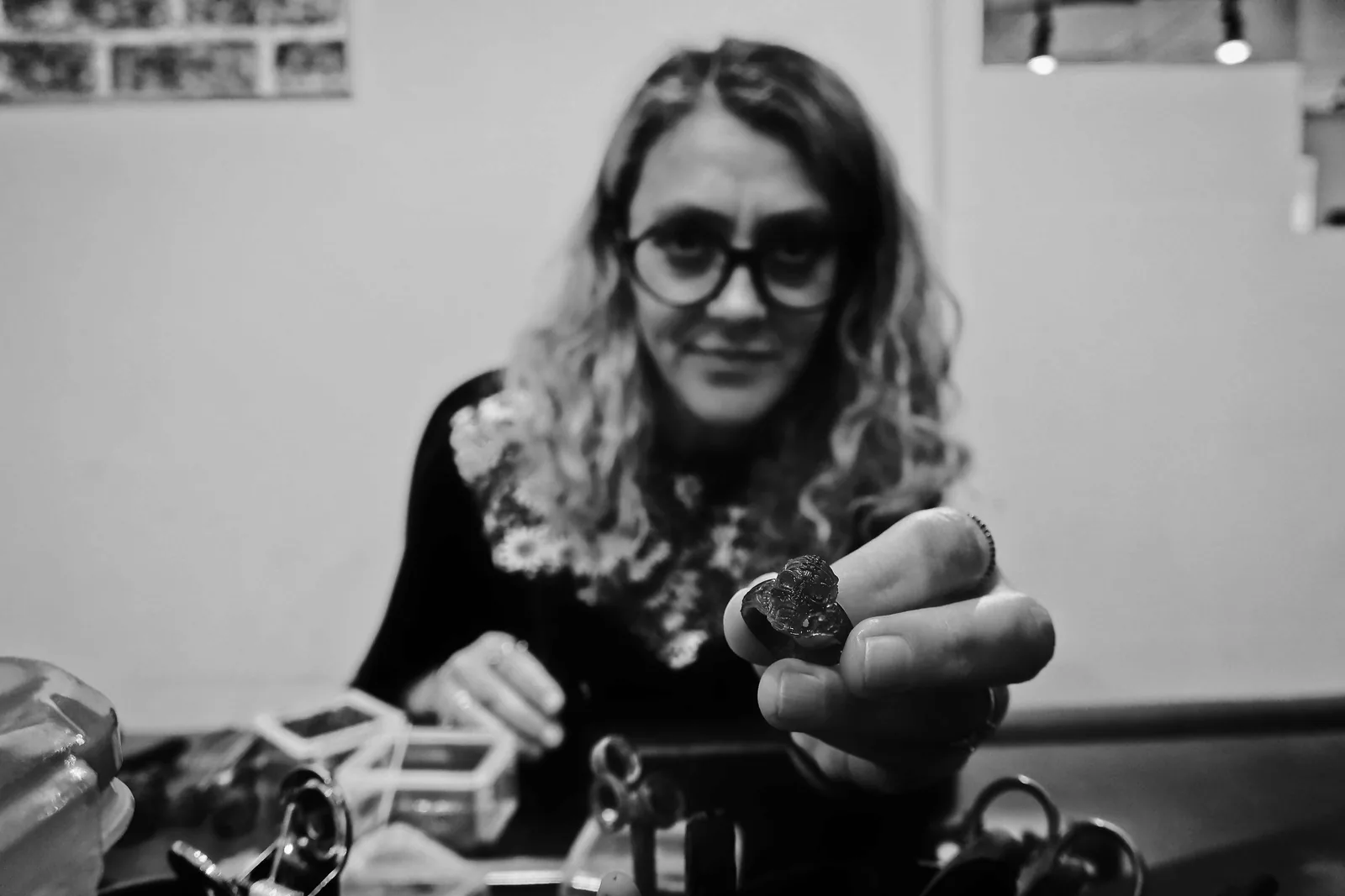 Woman holding up a jewellery piece in the workshop